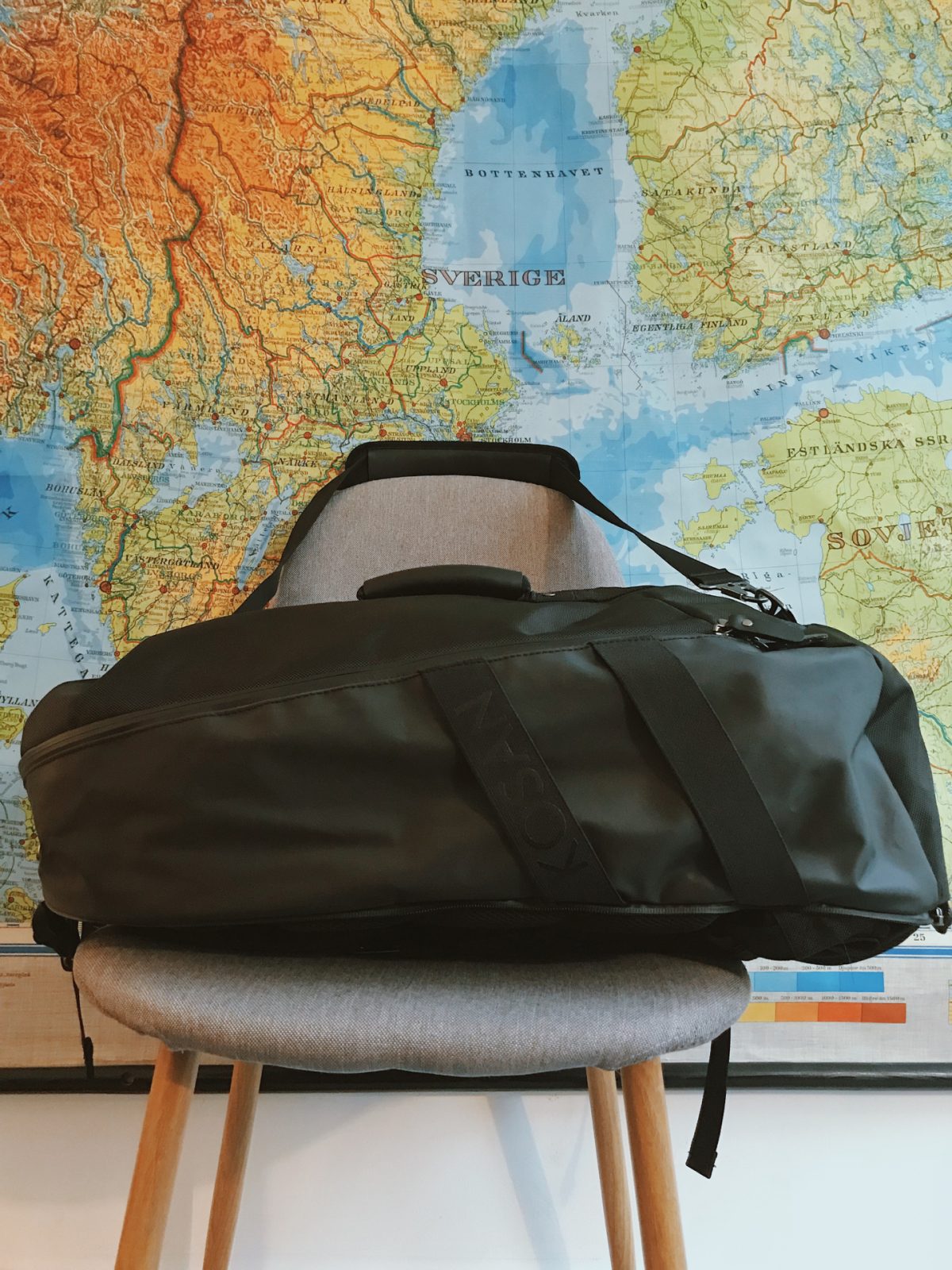 A black hiking backpack on a grey chair